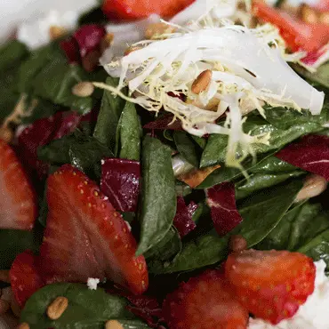 Close-up of strawberry and spinach salad with shaved cheese