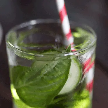 Iced drink with mint leaves and a striped straw