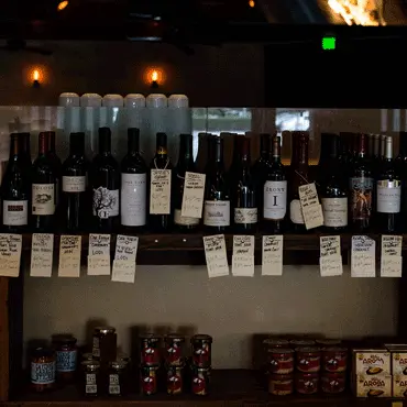 Wine bottles with handwritten labels on a market shelf