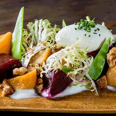 Mixed vegetable salad topped with a poached egg
